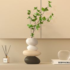 there is a vase with some plants in it on top of a shelf next to candles