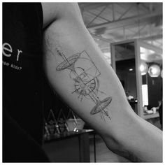 a black and white photo of a man's arm with a plane tattoo on it