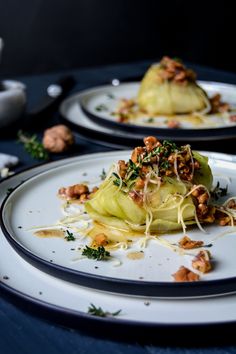 two white plates topped with food on top of a blue table