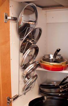 an open cupboard with pots and pans on it