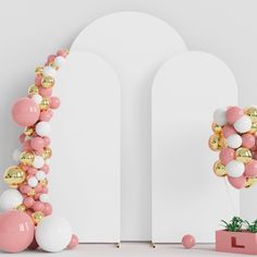 pink and white balloons are arranged in the shape of an arch, with gold accents