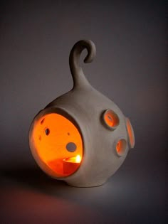 an odd looking light that looks like a vase with holes in the front and sides