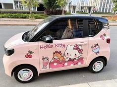 a pink hello kitty car is parked on the street