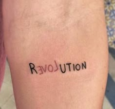 the word revolution written on someone's leg is shown in small black letters, which are