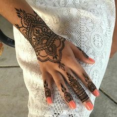 a woman's hand with henna tattoos on it