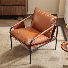 a brown leather chair sitting on top of a rug