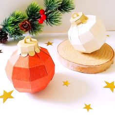 two paper pumpkins sitting on top of wooden slices