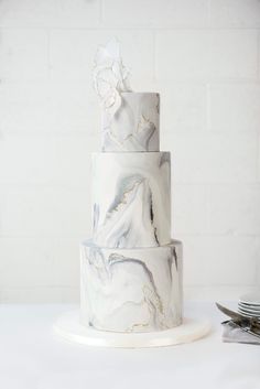 a three tiered marble cake with white flowers on top