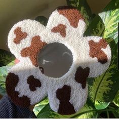 a hand is holding up a cow shaped pot holder