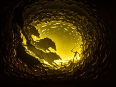 a paper sculpture with some animals in it's center and light coming from the top