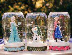 three snow globes sitting on top of a table with figurines in them