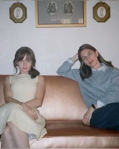 two women sitting on a couch in a living room