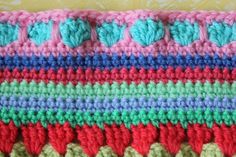 a crocheted dishcloth with hearts on the front and sides, in multi - colored yarn