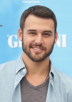 a close up of a person wearing a shirt and smiling at the camera with a smile on his face