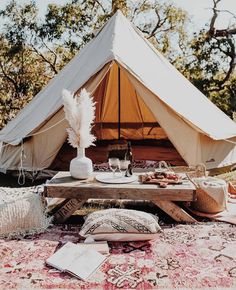 a teepee is set up in the middle of a field with food and drinks on it