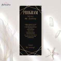 a black and gold program card with the words program on it, surrounded by seashells