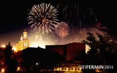 fireworks are lit up in the night sky with buildings and trees behind them, as well as a clock tower