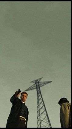 two men standing next to each other in front of a radio tower