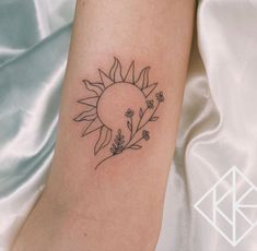 a small sunflower tattoo on the arm