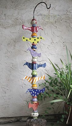 a colorful wind chime sitting next to a potted plant