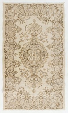 an antique rug with many different patterns and colors on the carpet is shown in white, brown