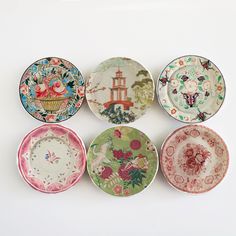 six plates with different designs on them are lined up in a row against a white background