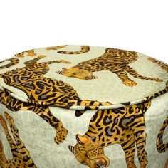 an animal print round ottoman cover with leopards on the front and back, sitting on top of a white surface