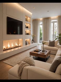 a living room filled with furniture and a flat screen tv mounted on the wall above a fire place