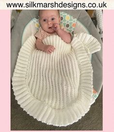 a baby laying in a crochet blanket on the floor