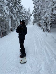 a man riding a snowboard down a snow covered slope