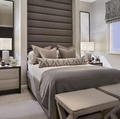 a bedroom with a large bed and two night stands in front of the headboard