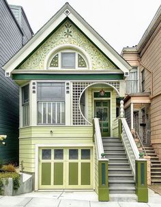 a green and white house with stairs leading up to it