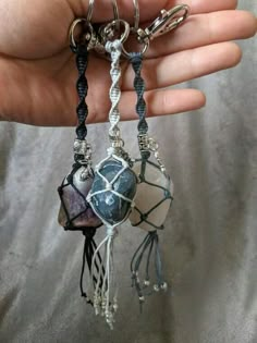 a person is holding some kind of keychain with beads and stones on it