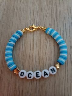 a blue and white beaded bracelet with the word ocean written in small letters on it