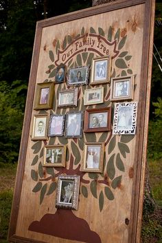 a family tree with pictures on it in front of some trees and grass, surrounded by framed photos