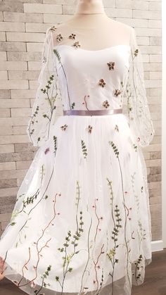 a white dress with flowers and leaves on it