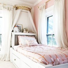 a bedroom with pink walls, white curtains and a bed in the middle is shown