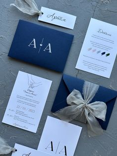 the wedding stationery is laid out on top of each other, including an envelope with a bow