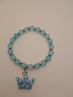 Pastel blue beaded bracelet with silver spacer beads and interchangeable pastel blue crown charm. Blue Nickel-free Charm Bracelet With Round Beads, Handmade Blue Charm Bracelet, Adjustable Blue Charm Bracelet With 8mm Beads, Handmade Blue Round Charm Bracelet, Blue Charm Bracelet With 8mm Beads, Blue Beaded Charm Bracelet, Blue Hypoallergenic Charm Bracelet With Round Beads, Adjustable Light Blue Bracelet With Round Beads, Hypoallergenic Blue Charm Bracelet With Round Beads