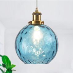 a blue glass light hanging from a ceiling