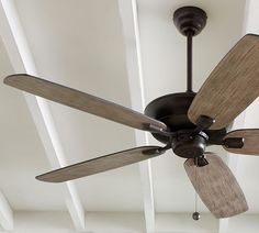 a ceiling fan with three wooden blades hanging from the ceiling