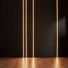 an empty room with wooden flooring and three lights on the wall behind it in front of a black wall