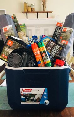 a blue cooler filled with various items on top of a table