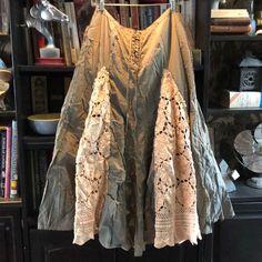 a dress hanging on a rack in front of a bookshelf