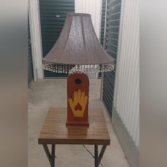 a lamp sitting on top of a wooden table next to a light in the shape of a hand