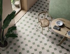 an aerial view of a table and chairs in a room with green tiles on the floor