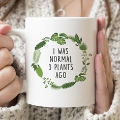 a woman holding a coffee mug with the words i was normal 3 plants ago