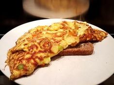 a piece of pizza sitting on top of a white plate next to a slice of bread