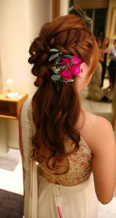 a woman with long hair wearing a flower in her hair