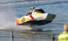 a speed boat in the water with people watching